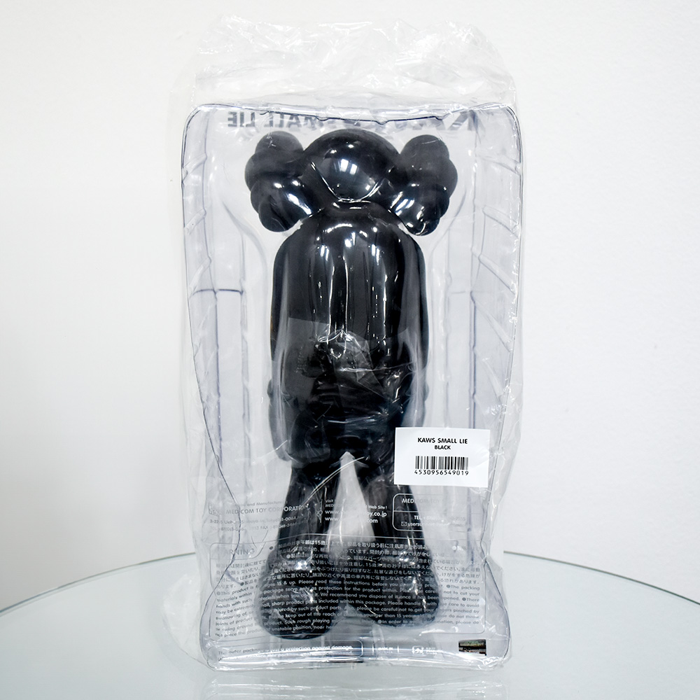 showing back of kaws small lie black in package