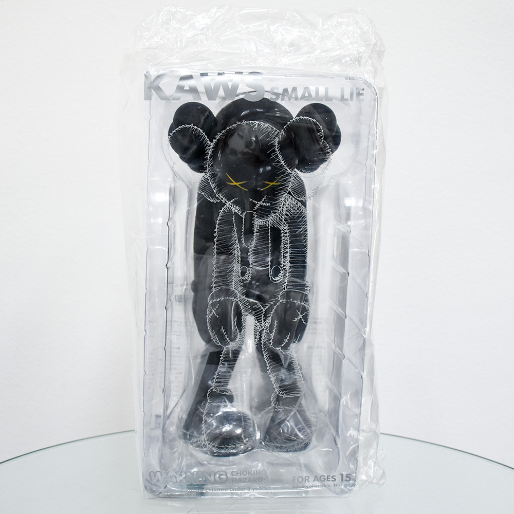 front of kaws small lie black in package